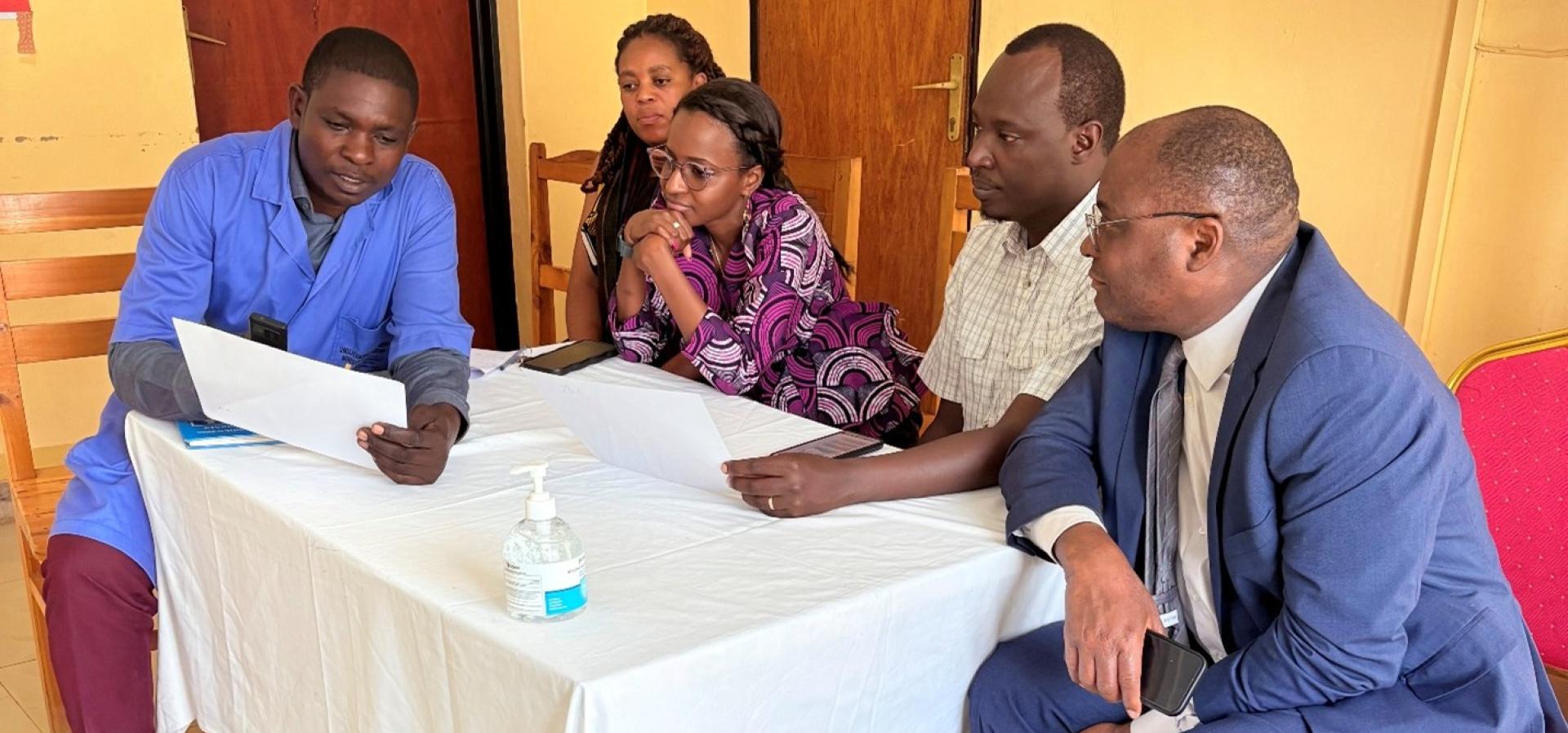 Rwanda impact story 5 people sit around a table