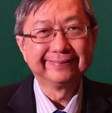 Asian man wearing glasses, a purple tie, and black blazer, looks into the camera in front of a green background