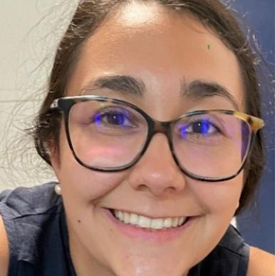 Woman wearing glasses smiles into the camera