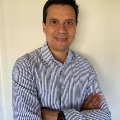 Man with crossed arms smiles into the camera