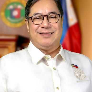 Man wearing glasses wearing a white shirt smiles into the camera