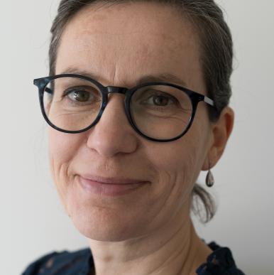 Woman wearing glasses smiles into the camera