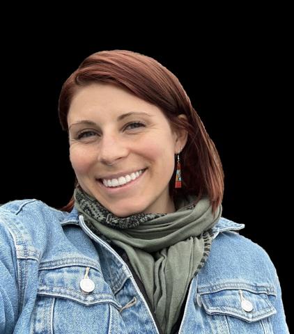 Woman with short red/brown hair, wearing a green scarf, smiles into the camera