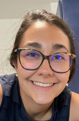 Woman wearing glasses smiles into the camera