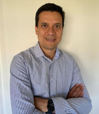 Man with crossed arms smiles into the camera